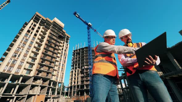 Professional Construction Engineers, Construction Architects Work on a Building Site with a Laptop