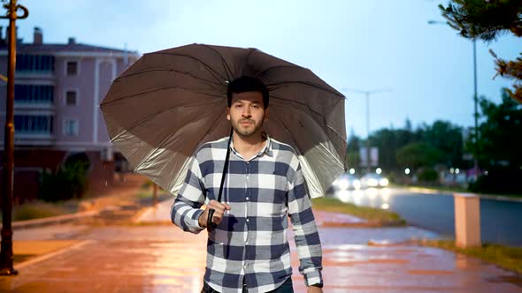 Young Man Walking Through Rainy Weather