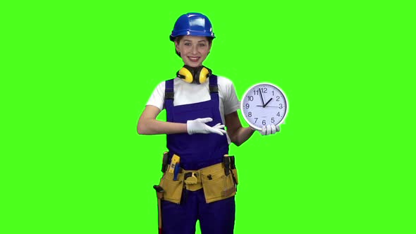 Brigadier Girl Is Holding a Large Clock and Showing Okay. Green Screen. Slow Motion