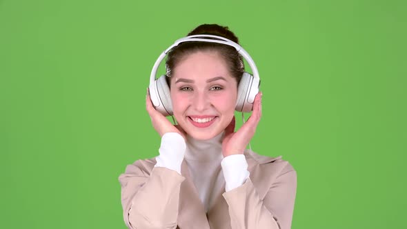 Woman Listens To Melodious Songs in the Headphones. Green Screen