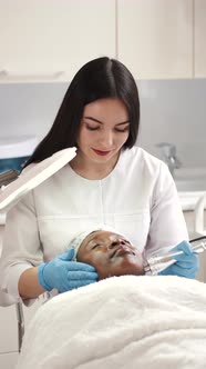 Cosmetologist Doing Facial Massage Manually to African Client