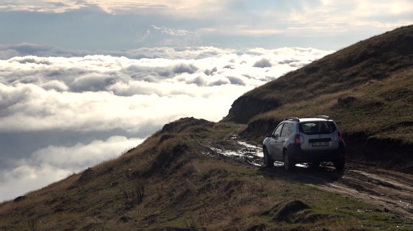 Car Going on Mountain Pass Above the Clouds