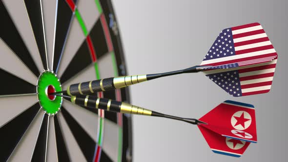Flags of the USA and North Korea on Darts Hitting Bullseye