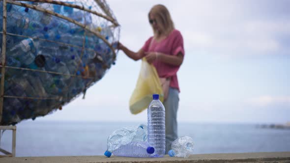Blurred Woman Putting Plastic Waste in Special Place on Beach Coast As Unrecognizable Millennial