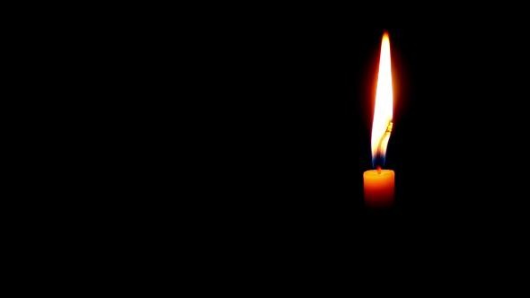 One Candle Burning on a Dark Background