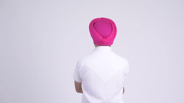 Rear View of Indian Sikh Man with Turban Pointing Finger