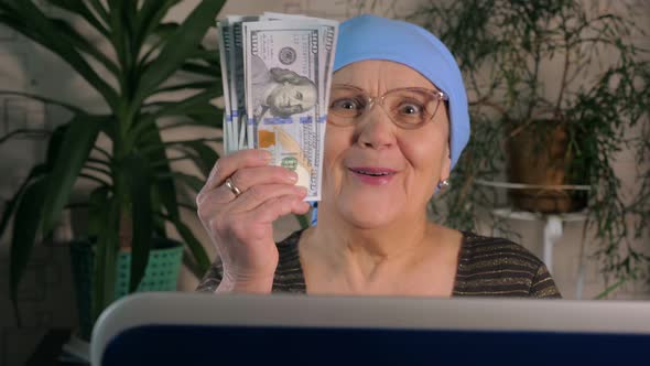 An Elderly Woman Uses a Laptop To Make Money on the Internet.