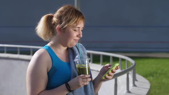 Chubby Woman Using Phone and Drinking Smoothie