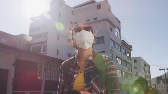 Mixed race woman wearing medical coronavirus mask on the street