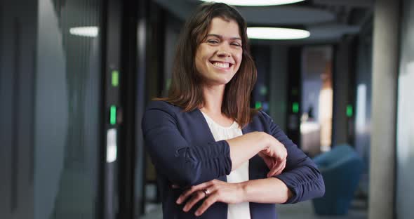 Portrait of smiling caucasian businesswoman with brown hair in modern office