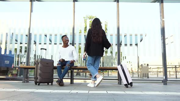 Asian Girl with Suitcase Approaching to Stylish Black-Skinned Friend which Waiting for Her