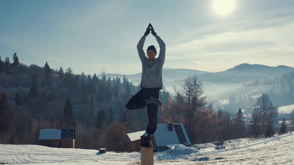 Athlete at the Top of the Mountain Doing Stretching. Training in the Winter. Aerial View