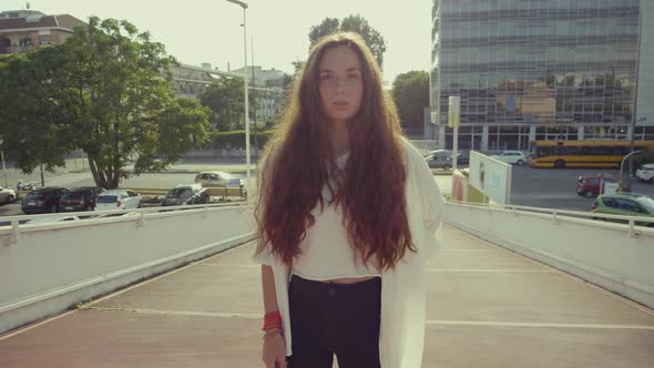 Slow motion shot of young woman with long brown hair in city