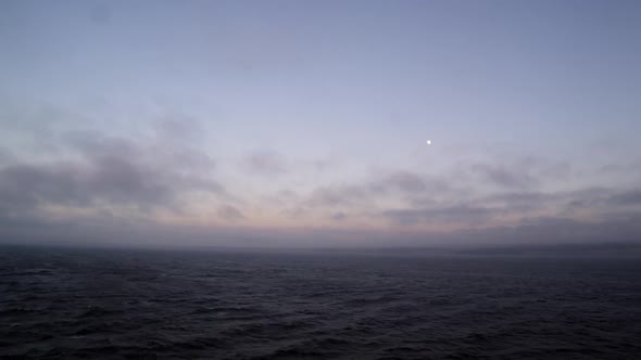 View of ocean and clouds at dusk from boat