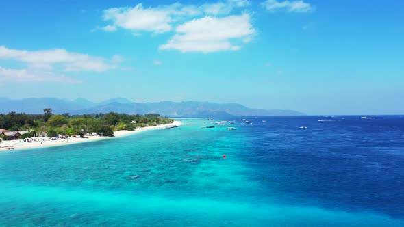 Aerial flying over seascape of tropical lagoon beach break by blue ocean with white sand background 