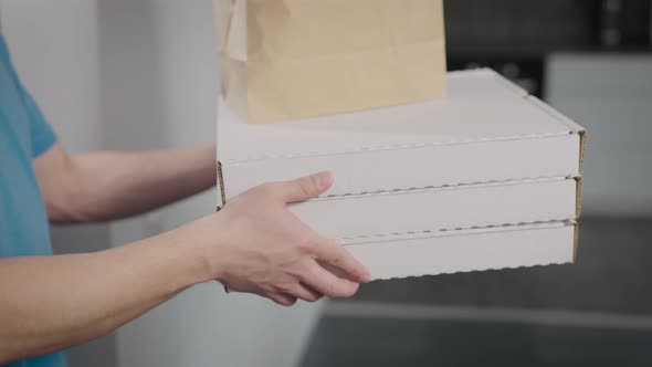 A Food Delivery Man Hands Over the Order to a Woman