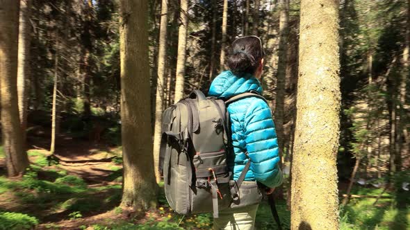 Hiking Woman Walk with a Hiking Backpack in Spring Green Forest