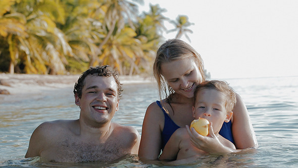 Family Of Three Relaxing In Sea Water In Tropics