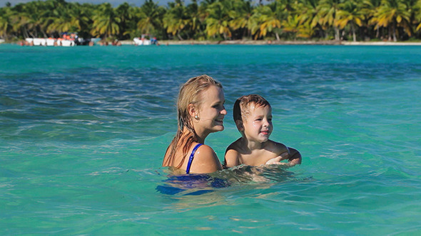 Mother And Son Playing In Clear Sea Water