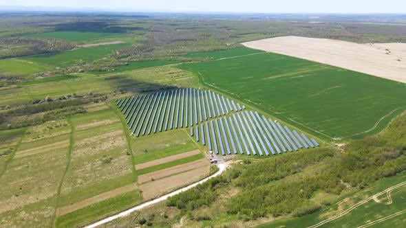 Aerial view of big sustainable electric power plant with many rows of solar photovoltaic panels