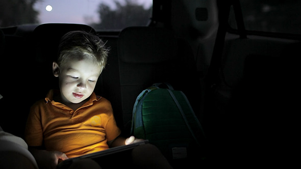 Little Boy Using Tablet Pc During Car Travel