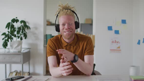 Albino african american man with dreadlocks making video call on the laptop