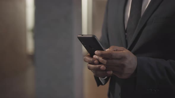 Unrecognizable Businessman Typing on Mobile Phone