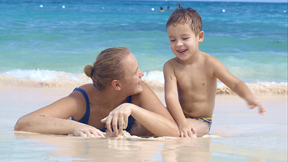 Mother And Son Playing On The Beach