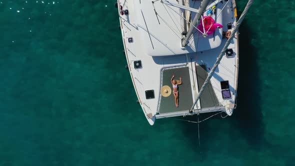 Woman in Bikini Tanning and Relaxing on a Summer Catamaran Sailing Cruise