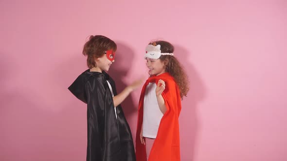 Cute Kids in Superhero Costumes Pose in Studio on Pink Background