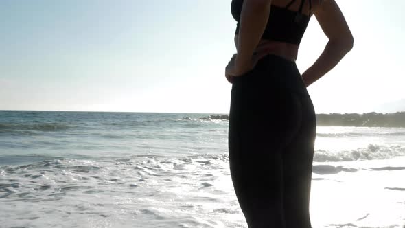 Athletic woman at the beach relaxing and enjoying the view after her workout