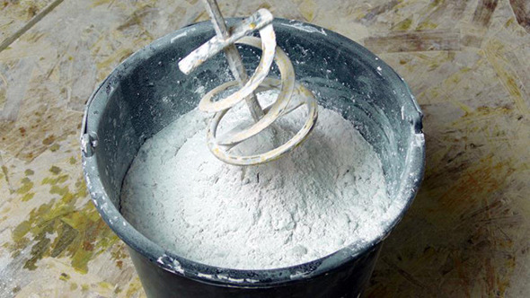 Rotating Whisk Mixer Immersed in Plaster Mix in Bu