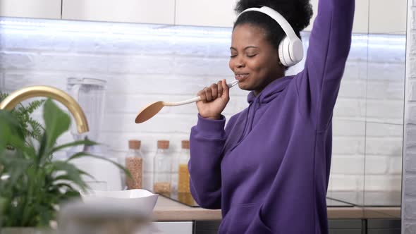 African American Black Handsome Woman Cooking Dancing with Headphones Enjoy Life Listening Favourite