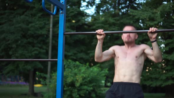 Man Makes Pullups on Turnstile