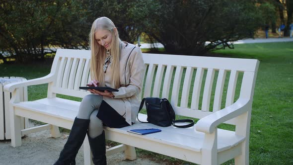 Happy Woman with Tablet in the Park