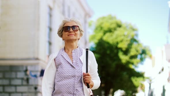 Happy Senior Woman Walking Along Summer City