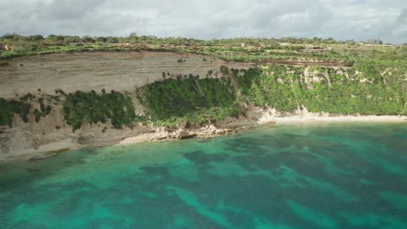 AERIAL: Sunny Happy Day in Ta Kalanka Sea Cave Bay with Majestic Turquoise Mediterranean Sea