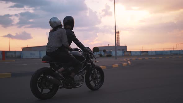 Young Couple in Helmets Riding on Motorcycle in City During Sunset Slow Motion