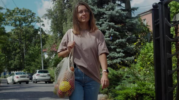 Woman with eco string bag. Conscious consumption concept.
