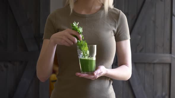 woman with celery juice in a glass at home