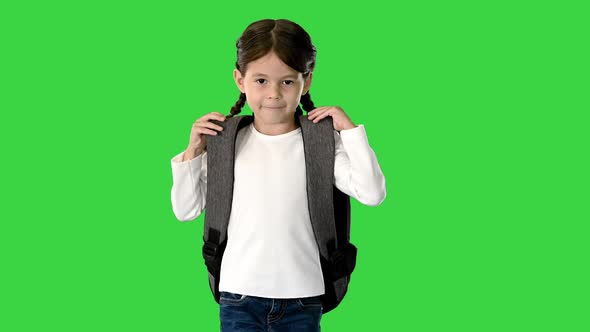 Smiling Little Girl Walking To School Holding Her Backpack and Looking at Camera on a Green Screen