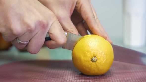 SLOW MOTION cutting a lemon citrus fruit in two parts with a knife. Cutting a lemon into two pieces