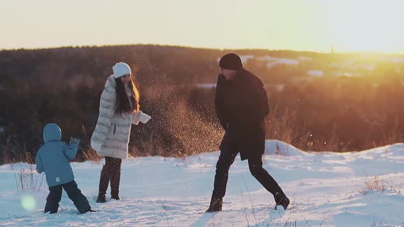 Active Family Members in Winter Dressing Play Snowballs