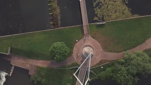 Aerial bird's eye view of a pedestrian bridge over a dam, forwardement