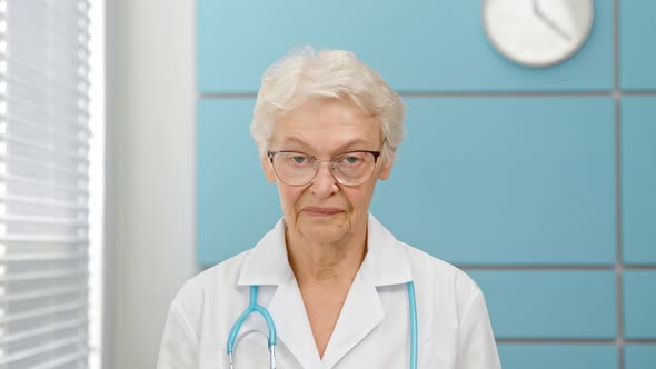 Senior short haired female doctor in white robe