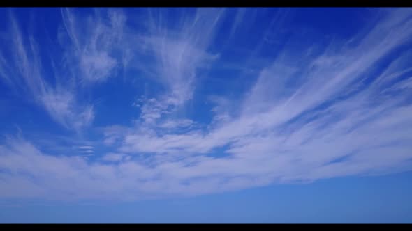 Aerial above nature of idyllic seashore beach holiday by shallow ocean with white sandy background o