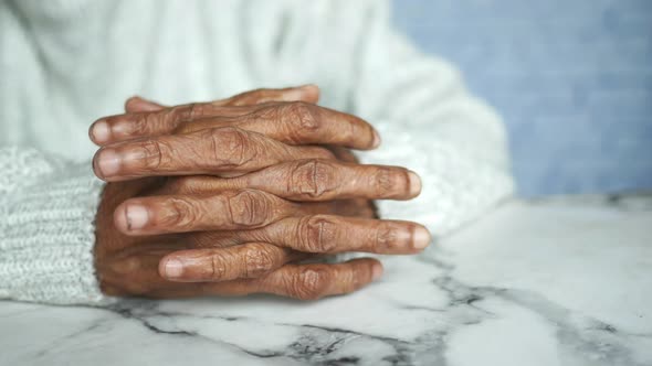 a Nervous Senior Women Hand on Table
