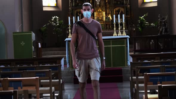 Young Man in a Mask Walks Inside an Empty Catholic Church Coronavirus Covid19