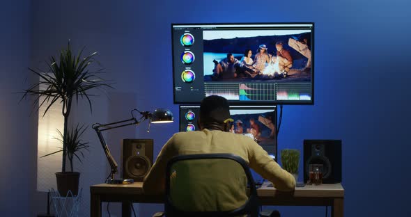 Young Man Sitting Back and Editing a Video Inside a Room