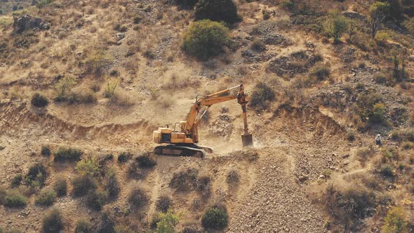 Yellow Dredger Digger Mine Excavate Rocky Ground in Countryside Mountain Area in Troodos